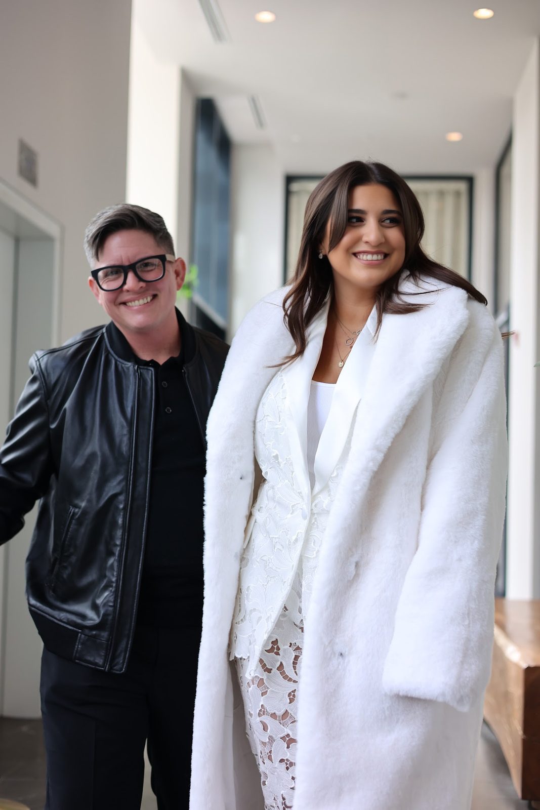Eli and Ashley smiling together in a hotel hallway