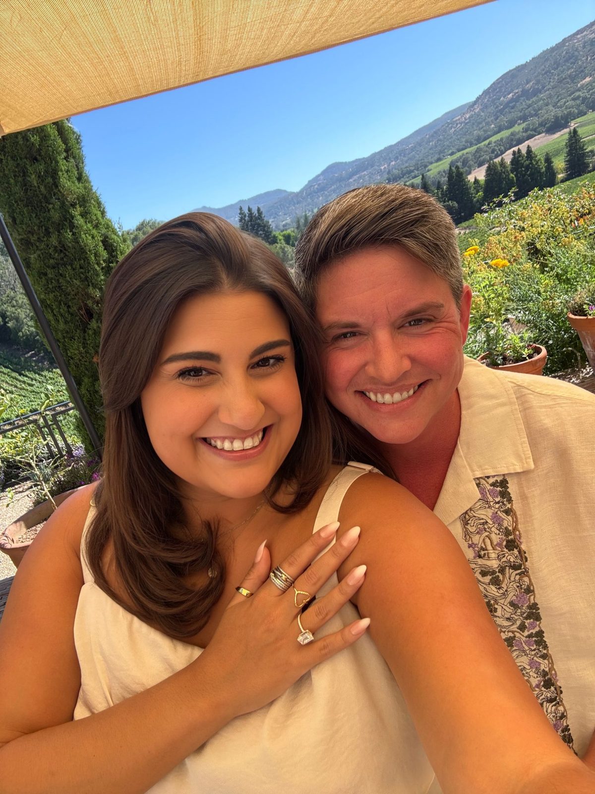 Close selfie of Ashley and Eli in the vineyards, Ashley's engagement ring visible